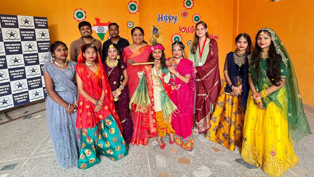 Students and teachers dressed in colorful traditional attire celebrating Krishna Janmashtami at San Marino Public Higher Secondary School, Gwalior.